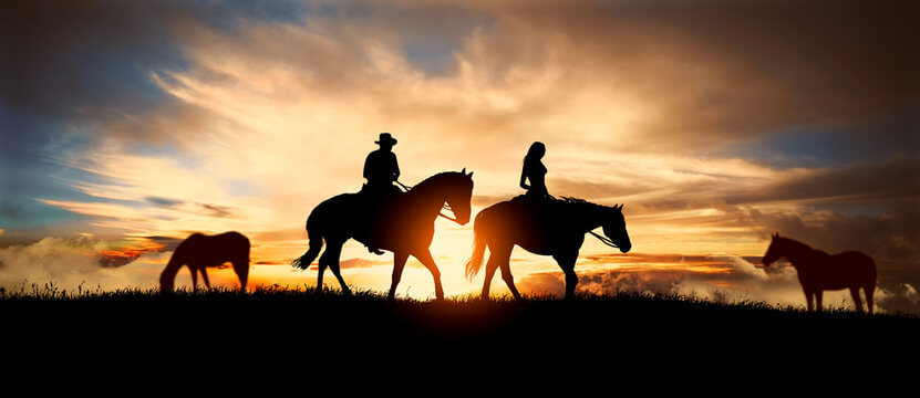 A couple riding horses together in a romantic setting.